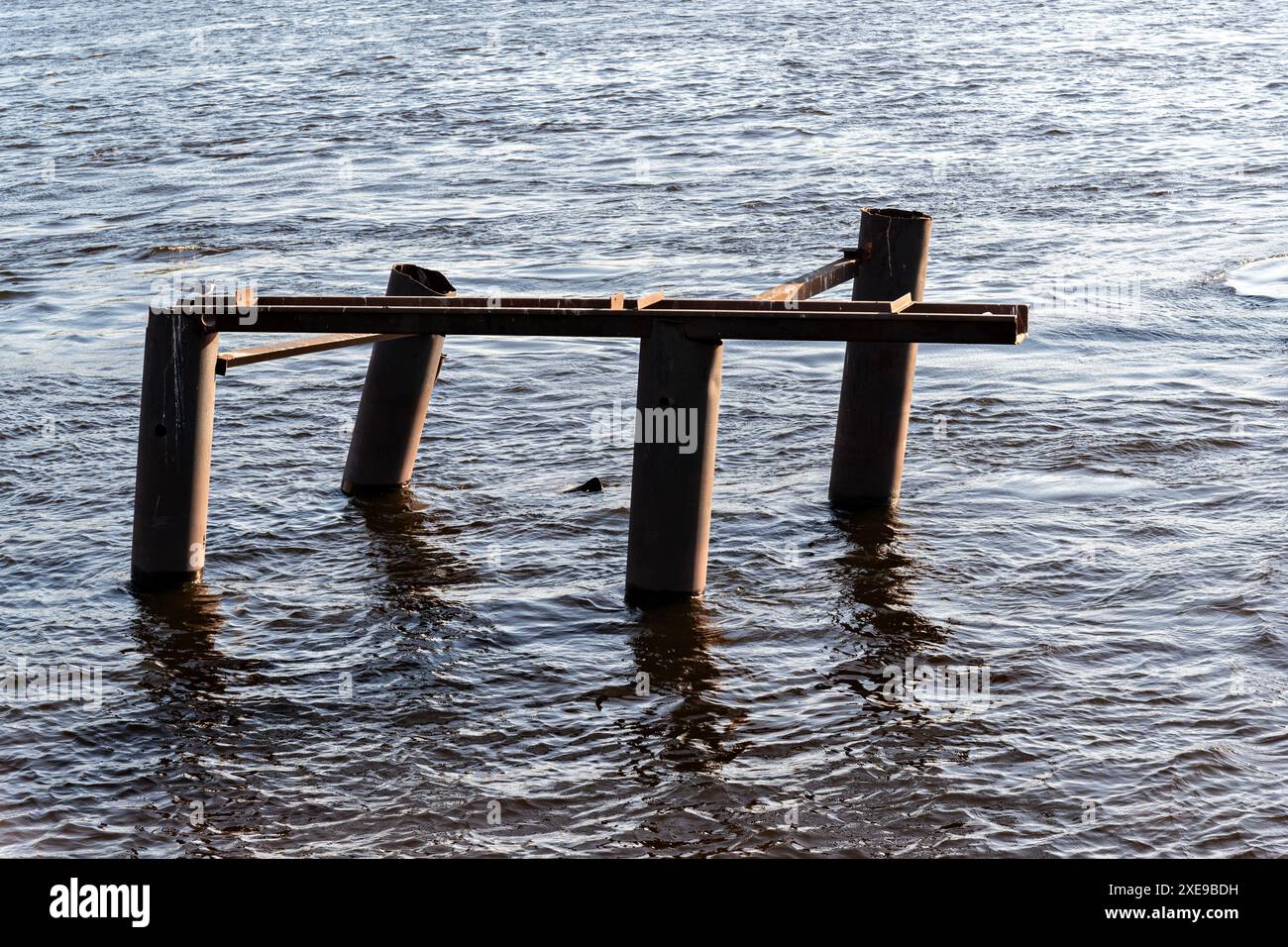 La vieille structure en fer dépasse au-dessus de la surface de l'eau de la rivière. Banque D'Images