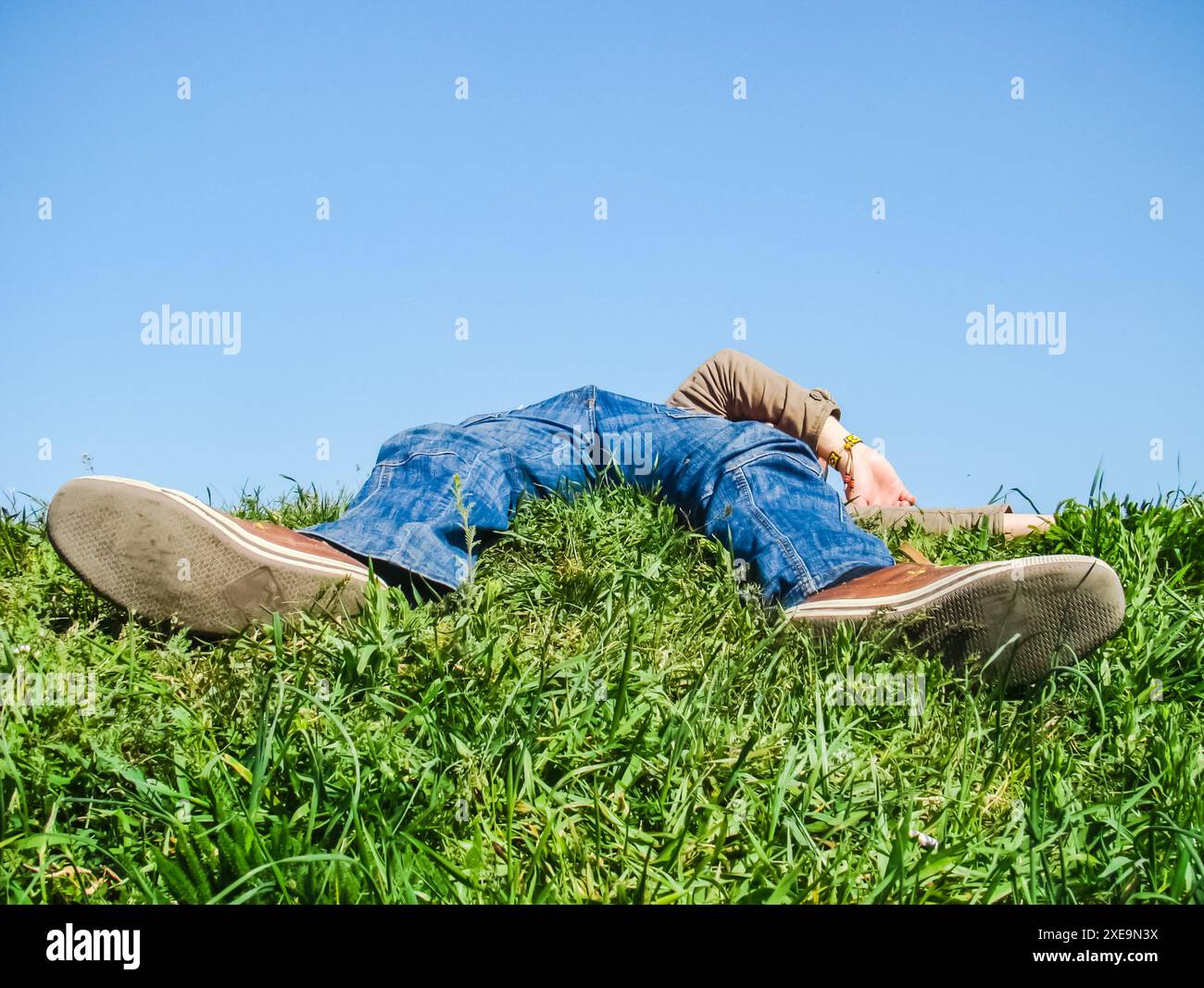 Un homme fatigué allongé sur l'herbe se repose Banque D'Images