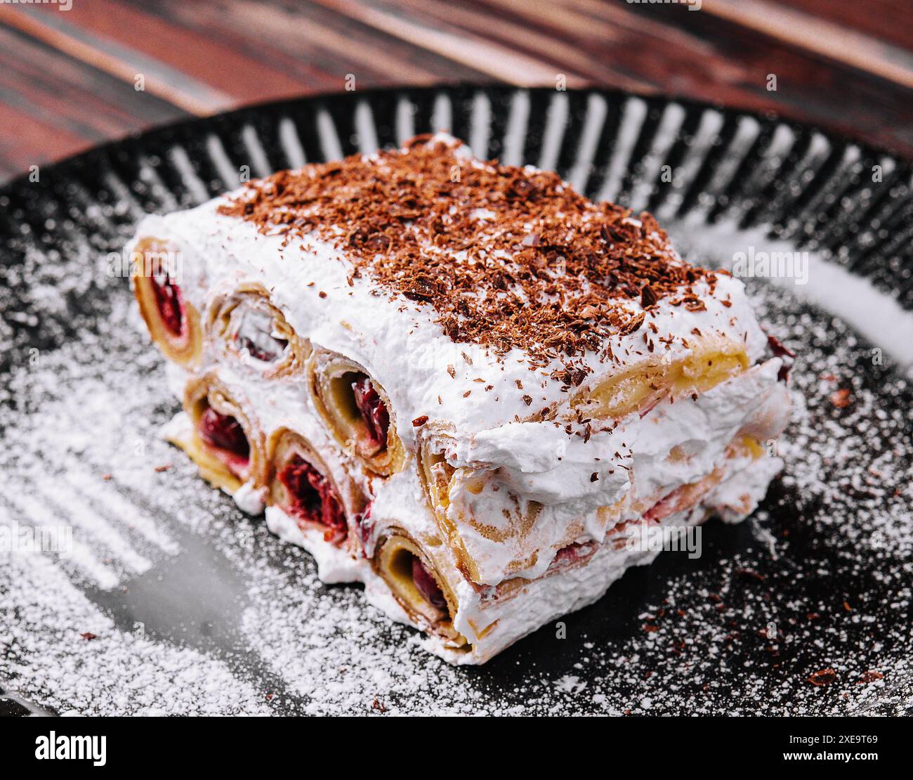 Trancher le gâteau forestier sur l'assiette noire Banque D'Images