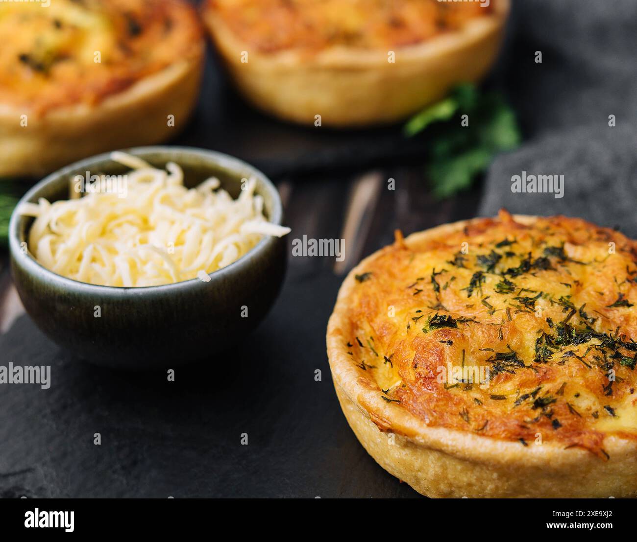 Tartes au cheddar et à l'omelette à l'oignon de printemps servies sur une planche de bois Banque D'Images