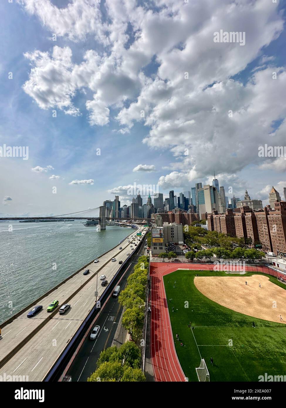 Urban Pulse : l'autoroute animée de Manhattan et le terrain de baseball encadrés par des gratte-ciel emblématiques par une journée ensoleillée. Banque D'Images