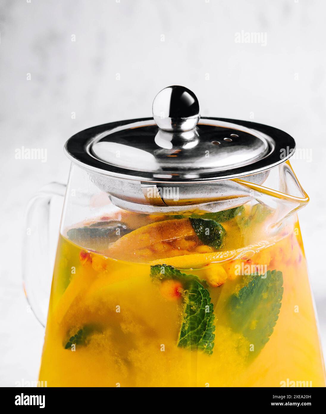 Thé à la menthe et à l'orange. boisson chaude aromatique dans un pot en verre. Banque D'Images