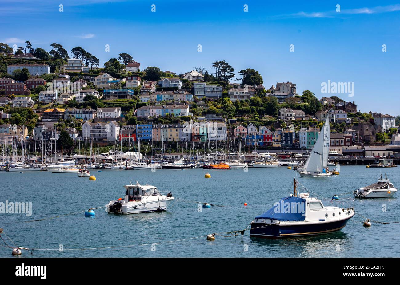 Dartmouth une ville balnéaire pittoresque dans le Devon avec des maisons colorées à flanc de colline, port de plaisance avec des yachts et des bateaux, et ciel bleu clair Banque D'Images