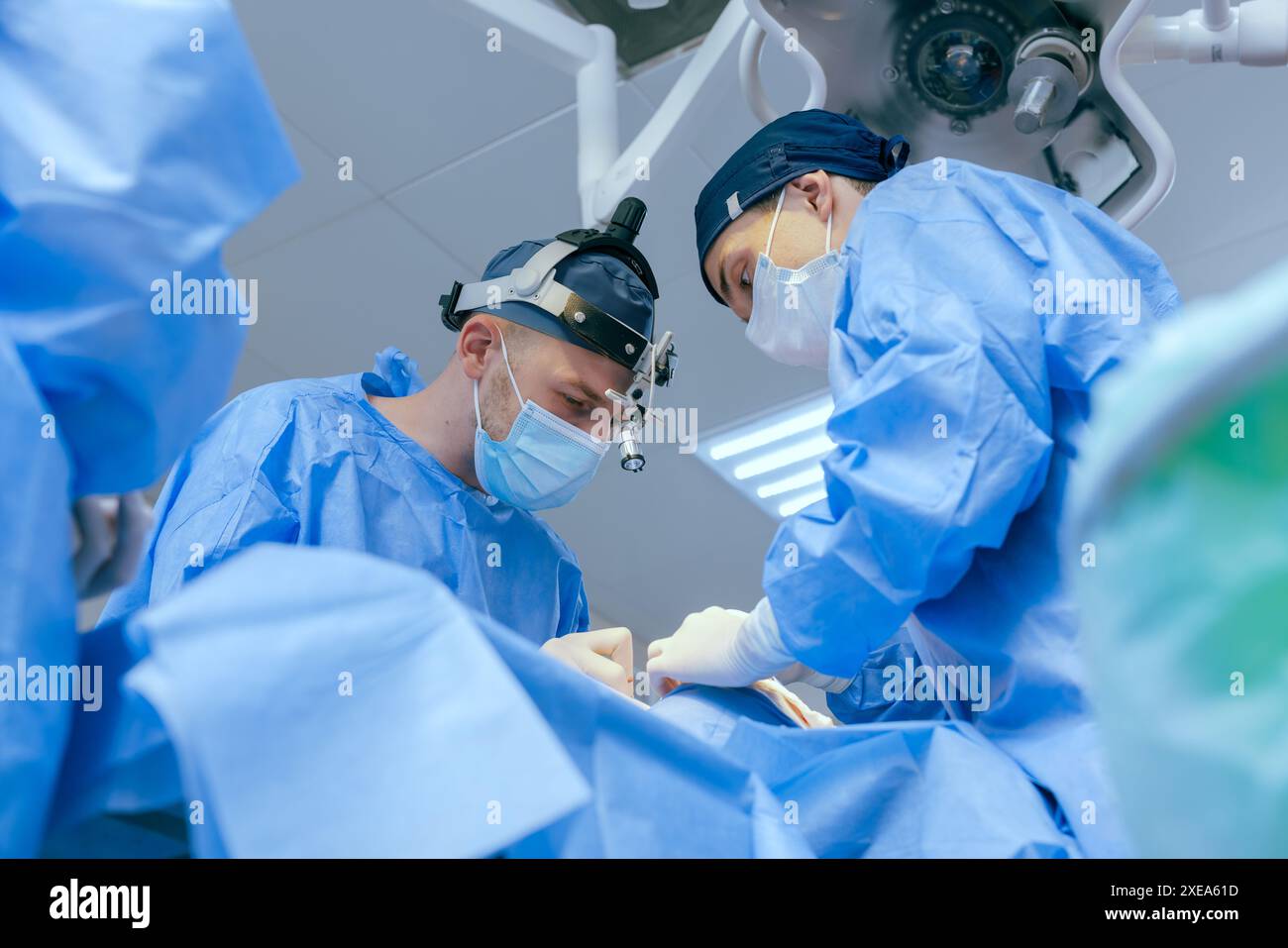 Les chirurgiens masculins effectuent la chirurgie dans la salle d'opération, chirurgien plastique dans la salle d'opération, Une équipe chirurgicale effectue une opération Banque D'Images