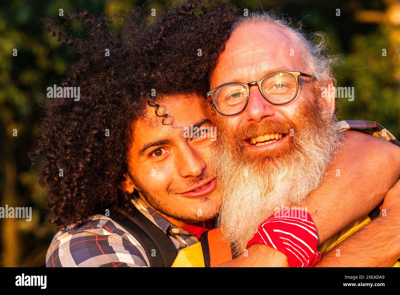 Étreinte chaleureuse entre deux hommes joyeux au coucher du soleil Banque D'Images