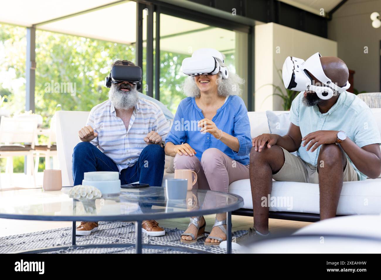 À la maison, groupe diversifié d'amis utilisant des casques VR, profitant de l'expérience de réalité virtuelle Banque D'Images