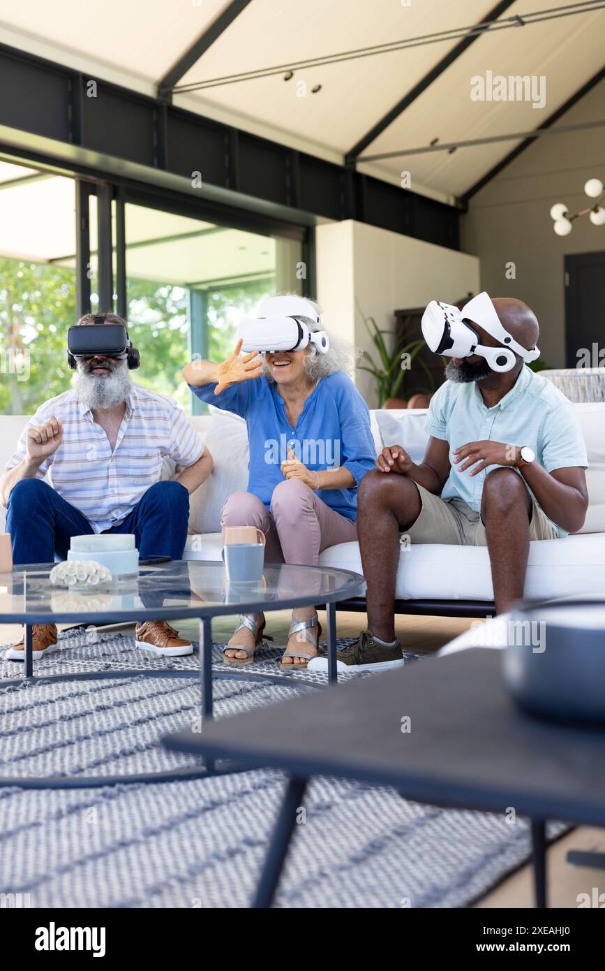 À la maison, groupe d'amis utilisant des casques VR, profitant de l'expérience de réalité virtuelle ensemble Banque D'Images