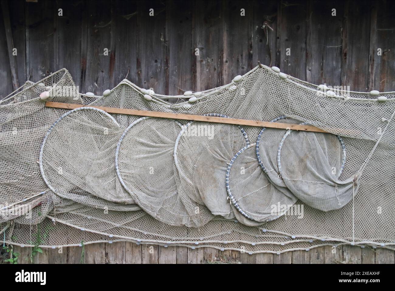 Des filets de pêche pendent pour sécher près d'un hangar à bateaux sur le lac Banque D'Images