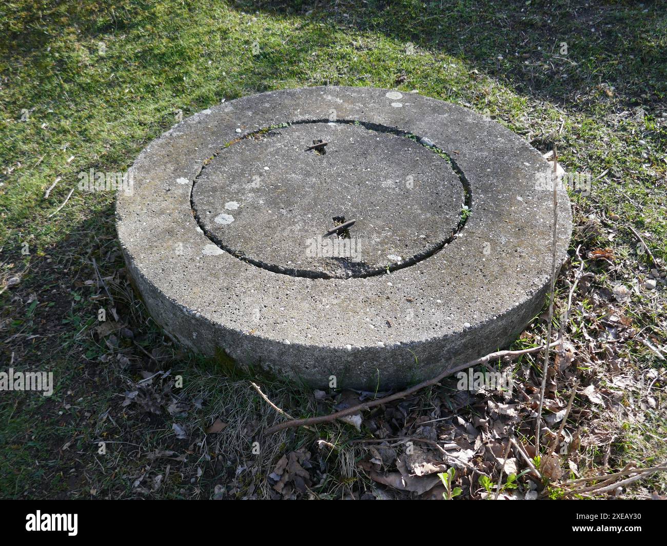 Trappe utilitaire de trou d'homme en béton à l'extérieur dans l'herbe Banque D'Images