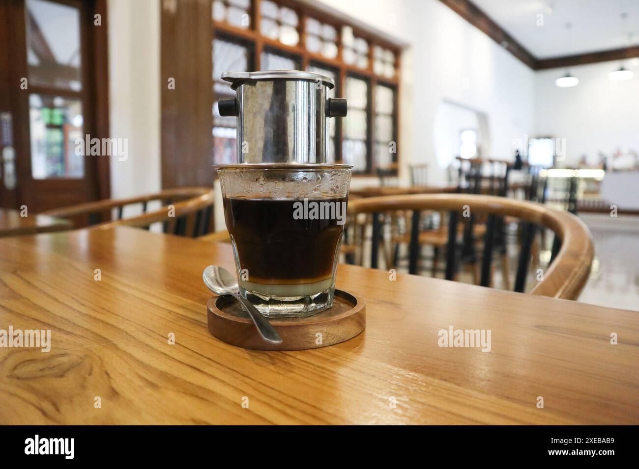 Goutte à goutte vietnamienne, café vietnamien au lait condensé dans des tasses en verre et cafetière traditionnelle en métal phin. Méthode traditionnelle de fabrication du vietname Banque D'Images