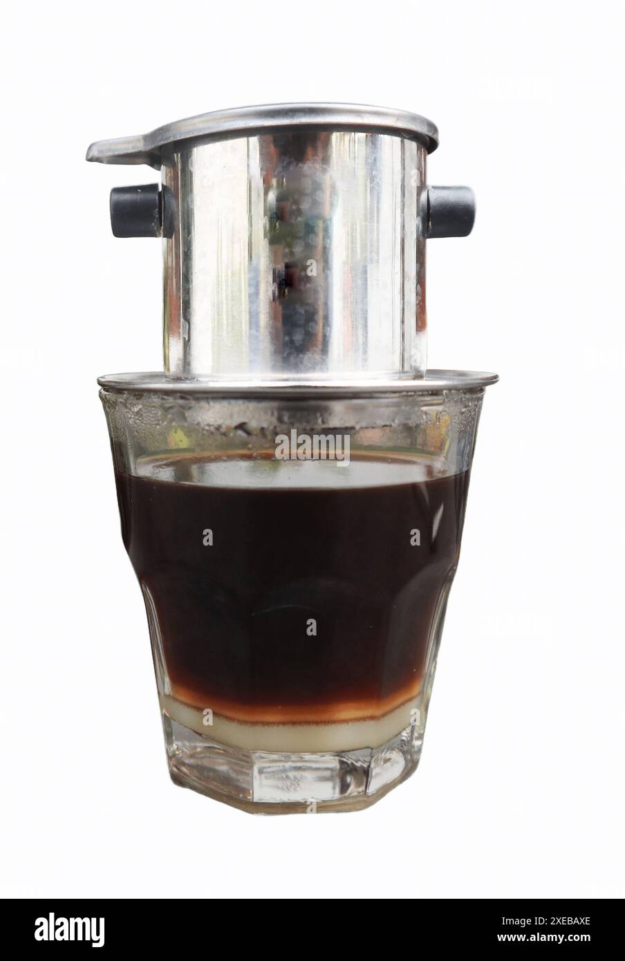 Goutte à goutte vietnamienne, café vietnamien au lait condensé dans des tasses en verre et cafetière traditionnelle en métal phin. Méthode traditionnelle de fabrication du vietname Banque D'Images