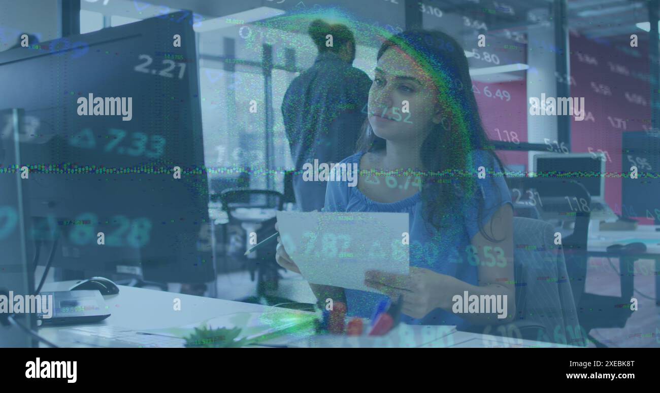 Image du traitement des données boursières contre une femme caucasienne utilisant l'ordinateur au bureau Banque D'Images