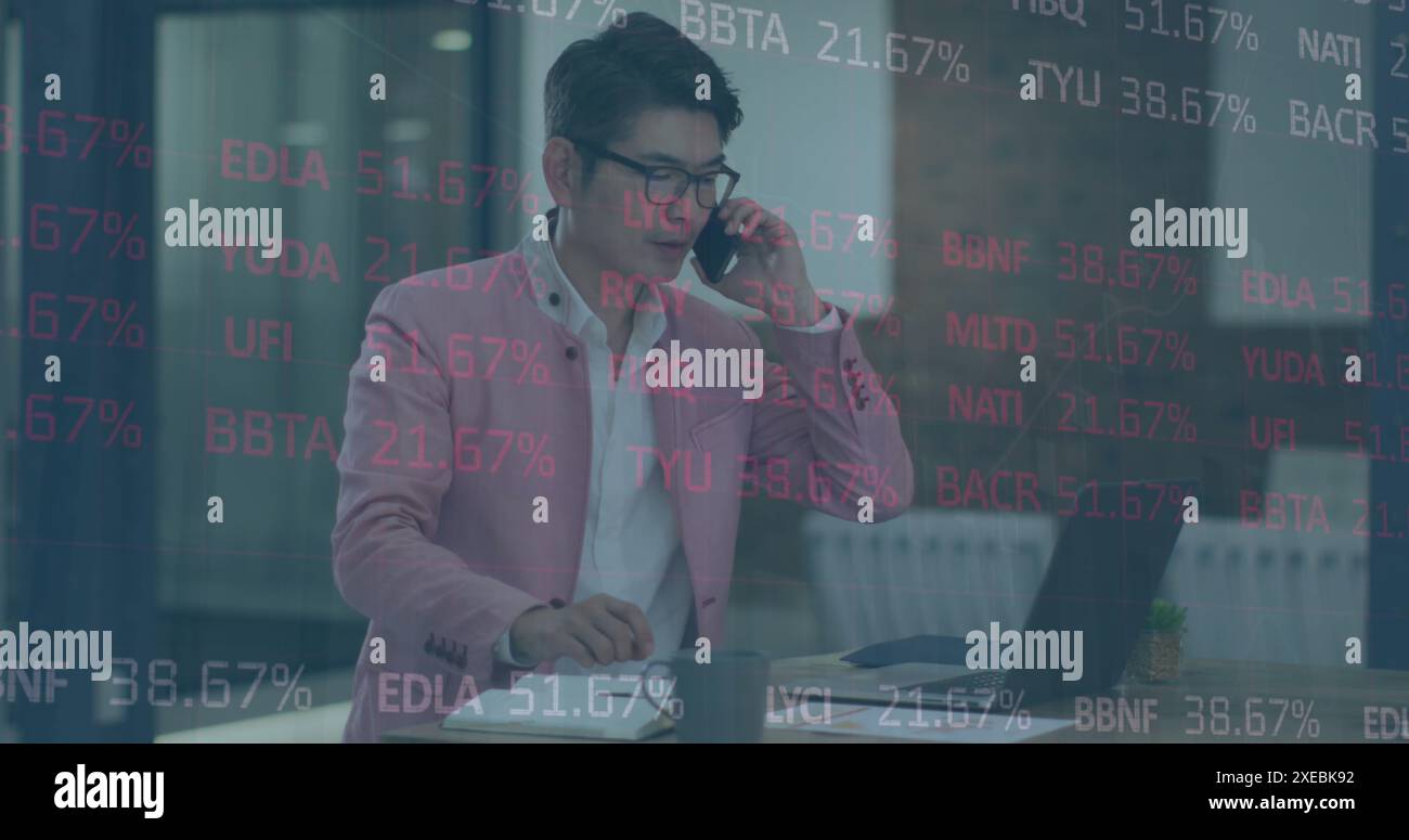 Image du traitement des données boursières contre un homme d'affaires asiatique parlant sur smartphone au bureau Banque D'Images