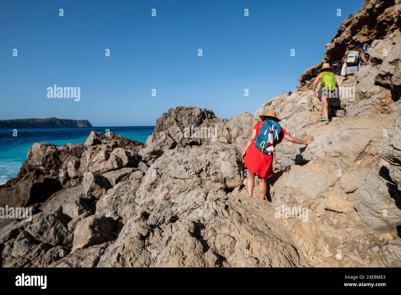 Famille marchant vers la plage de Coll Baix Banque D'Images