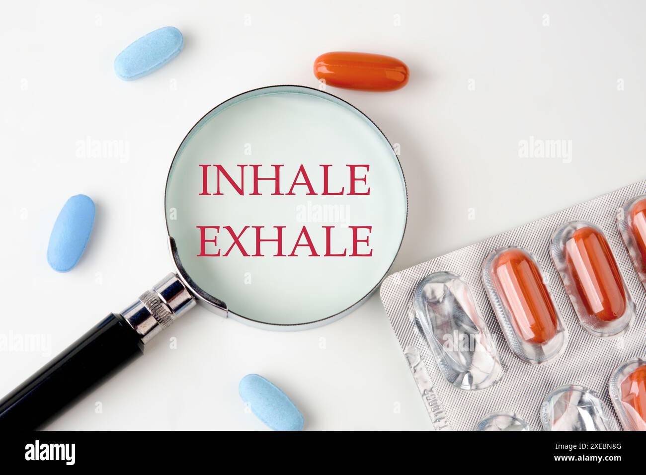 Concept étendu de la méditation. Inspirez - expirez écrit à travers une loupe à côté des pilules Banque D'Images