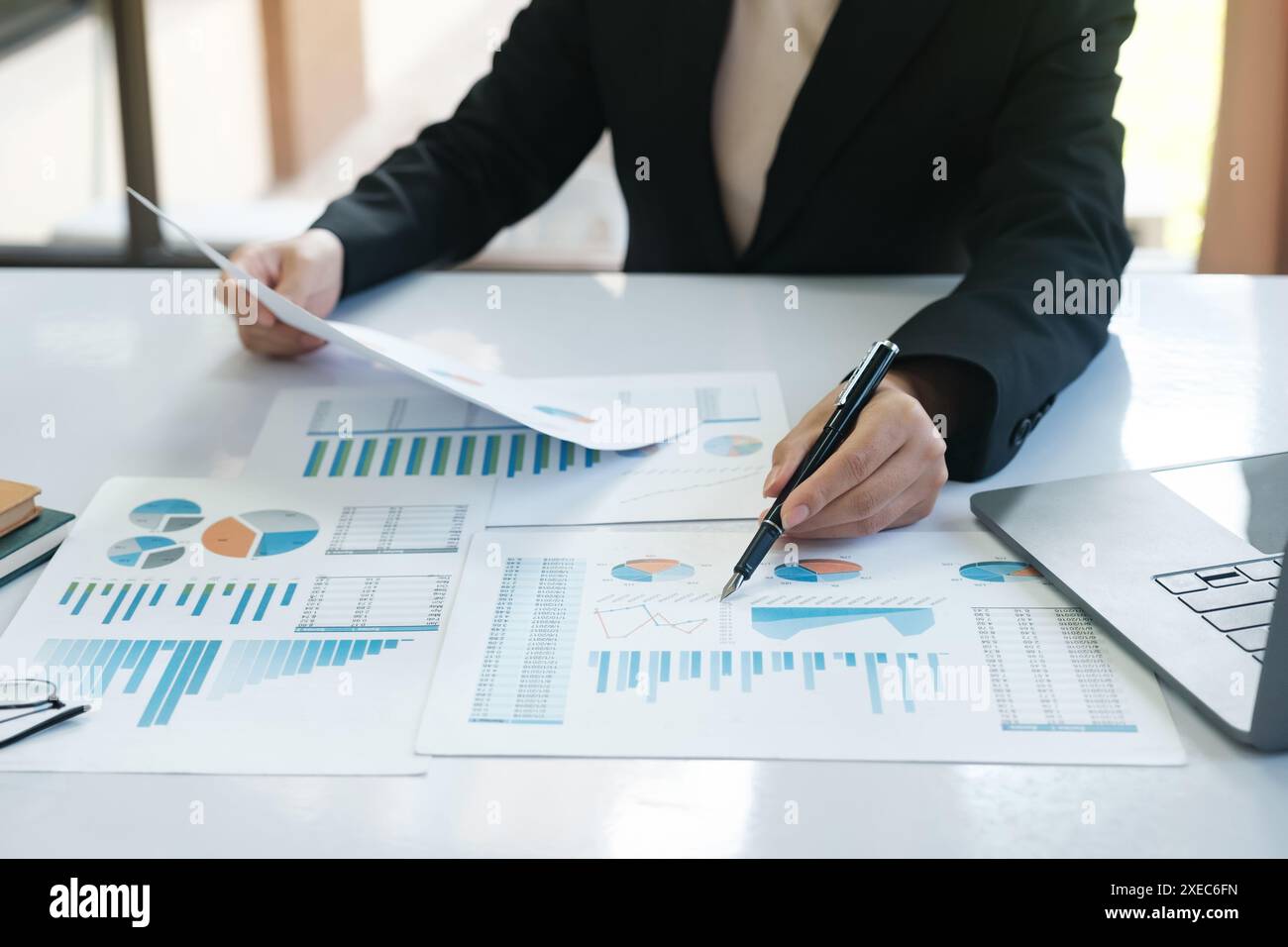 Un homme est assis à un bureau avec un stylo et une pile de papiers Banque D'Images