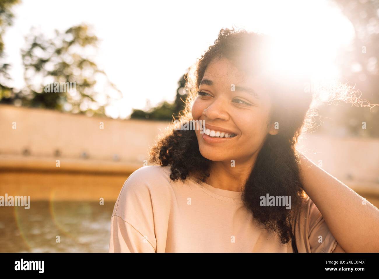 Portrait rapproché d'une jeune adolescente souriante de race mixte. Une jeune femme afro-américaine charmante dans un T-shirt beige est L. Banque D'Images