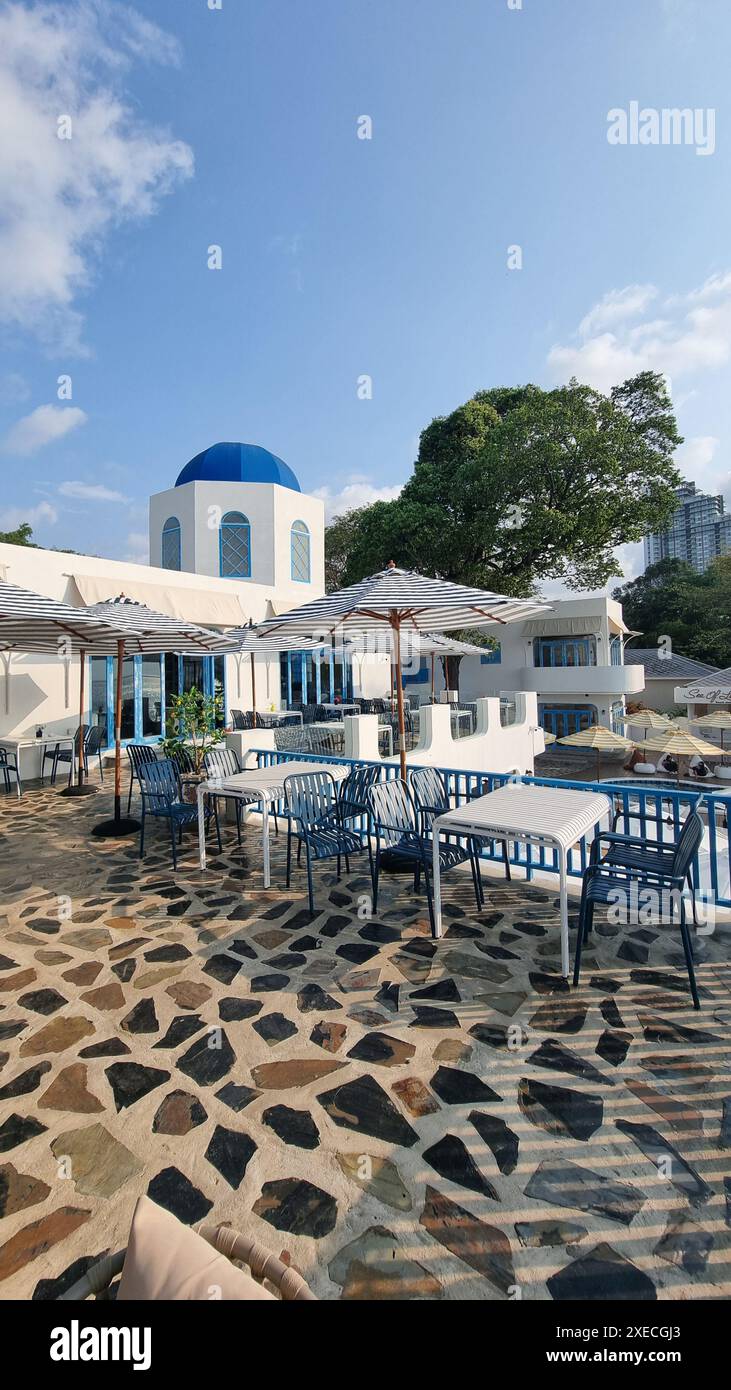 Un patio paisible avec des tables et des chaises placées contre un dôme bleu serein en arrière-plan Banque D'Images