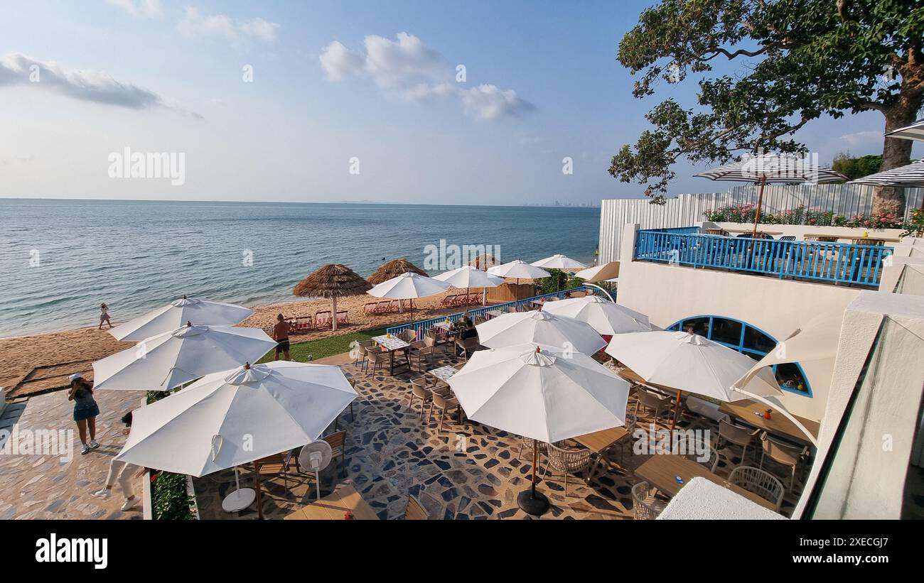 Un groupe de parasols colorés se tient haut sur une plage de sable, jetant de l'ombre et ajoutant un éclat de couleur à la scène paisible Banque D'Images