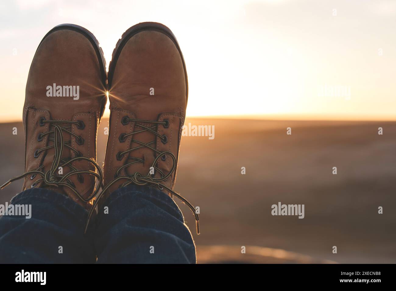 Pieds de femme atteignant la destination et assis au sommet de la colline ou de la montagne au lever du soleil. Hiver froid britannique. Concept de tourisme local. Banque D'Images