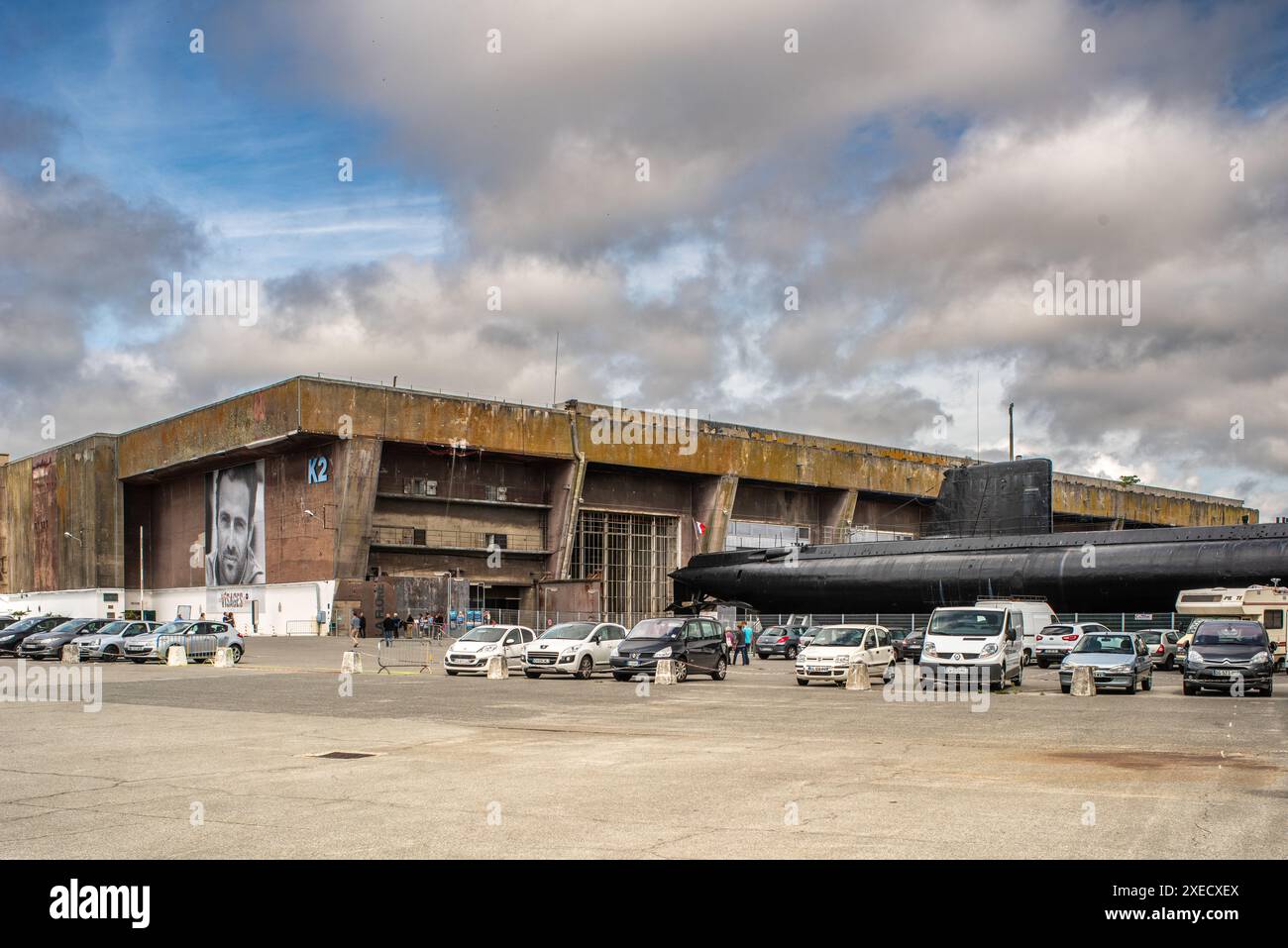 Base de sous-marins allemands de la seconde Guerre mondiale à Lorient, en Bretagne, en France, avec un sous-marin français des années 1960 amarré au milieu de grandes structures en béton. Banque D'Images