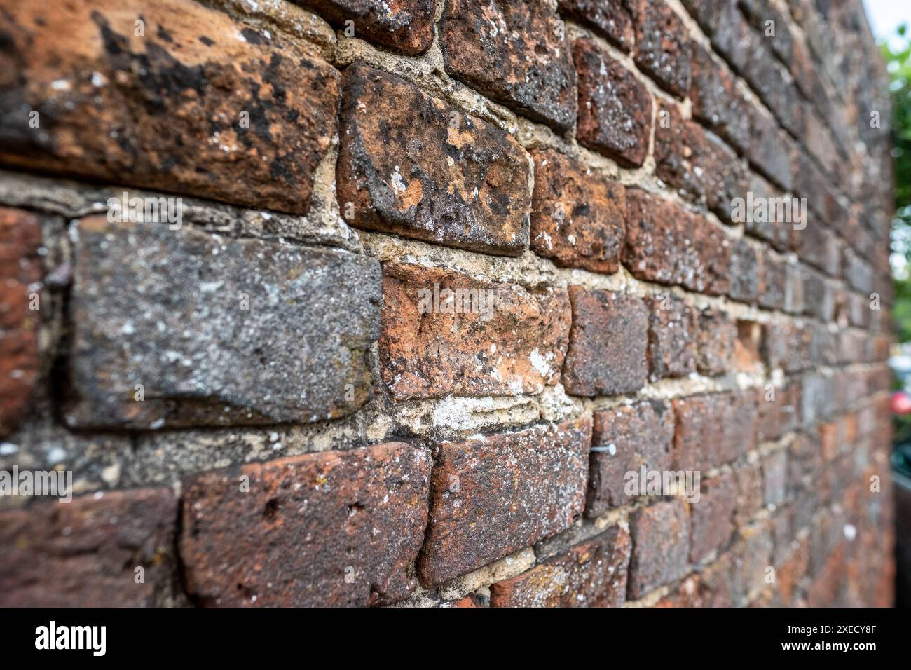 Vieux mur de briques altérées dans le besoin de repointer dans un village britannique rural Banque D'Images