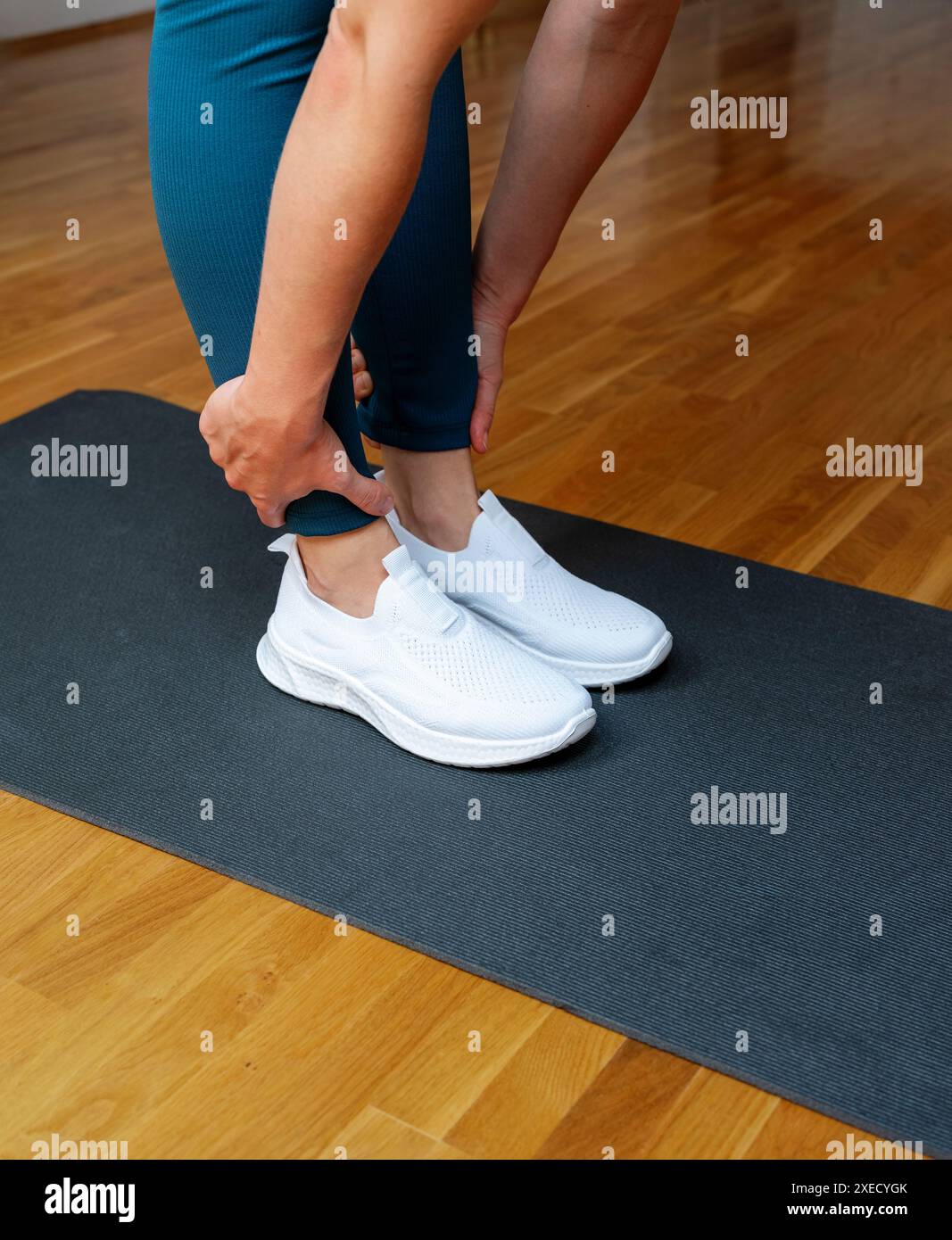 Gros plan photo des pieds et des mains d'une athlète féminine pendant l'exercice d'étirement physique. Banque D'Images