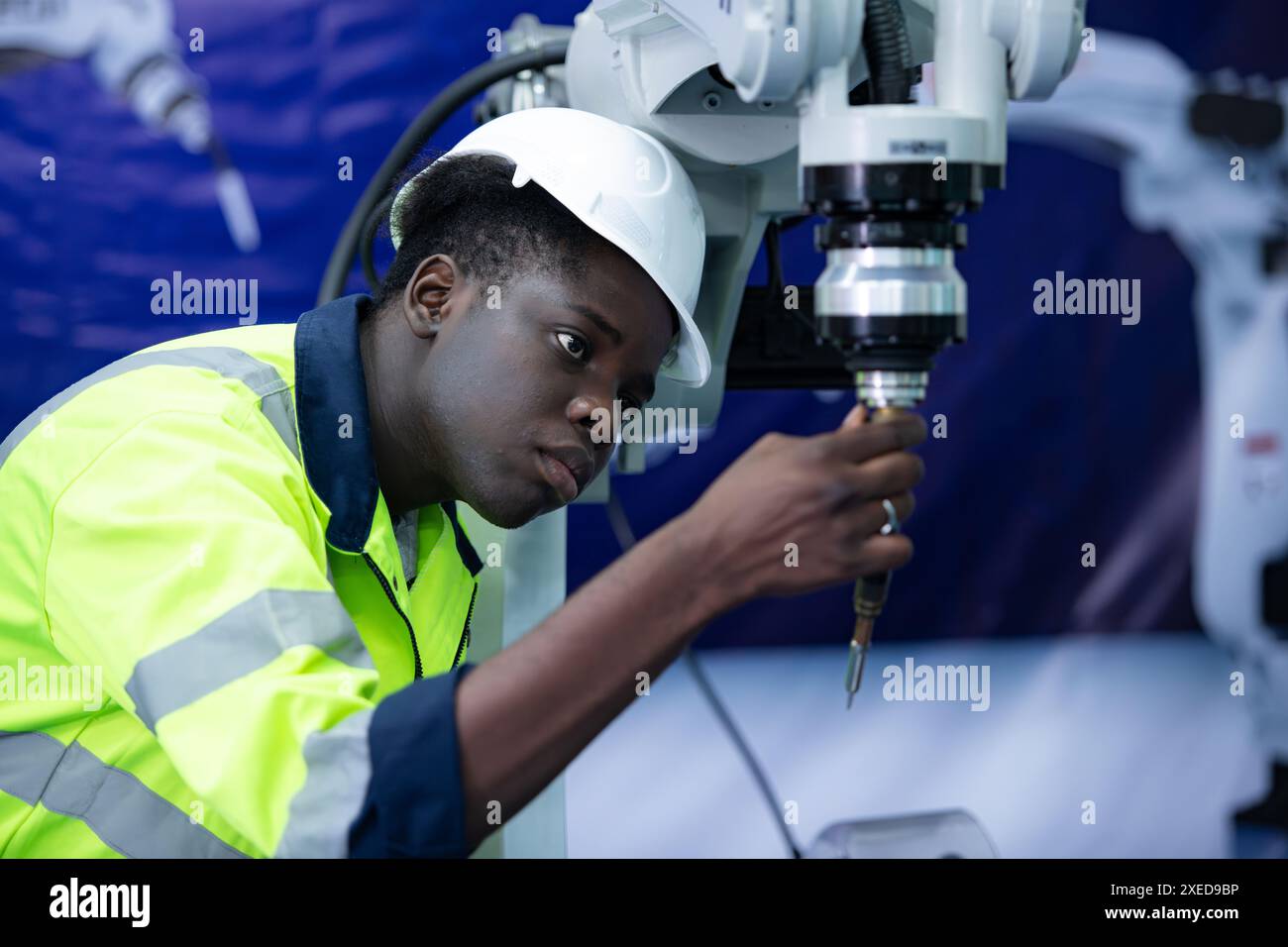 Technicien qui entretient un petit bras robotisé le fonctionnement d'un petit bras robotisé utilisé dans l'industrie est en cours de réparation. Banque D'Images