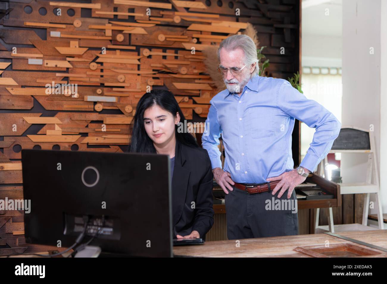 Un homme d'affaires et des femmes d'affaires travaillant sur ordinateur dans une salle de bureau moderne Banque D'Images