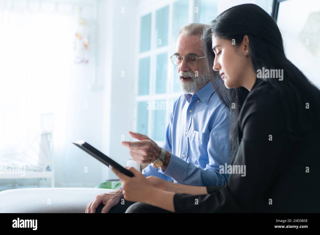 Cadres supérieurs et agents d'assurance fournissant des informations détaillées sur les affaires de police d'assurance pour les personnes âgées. Banque D'Images