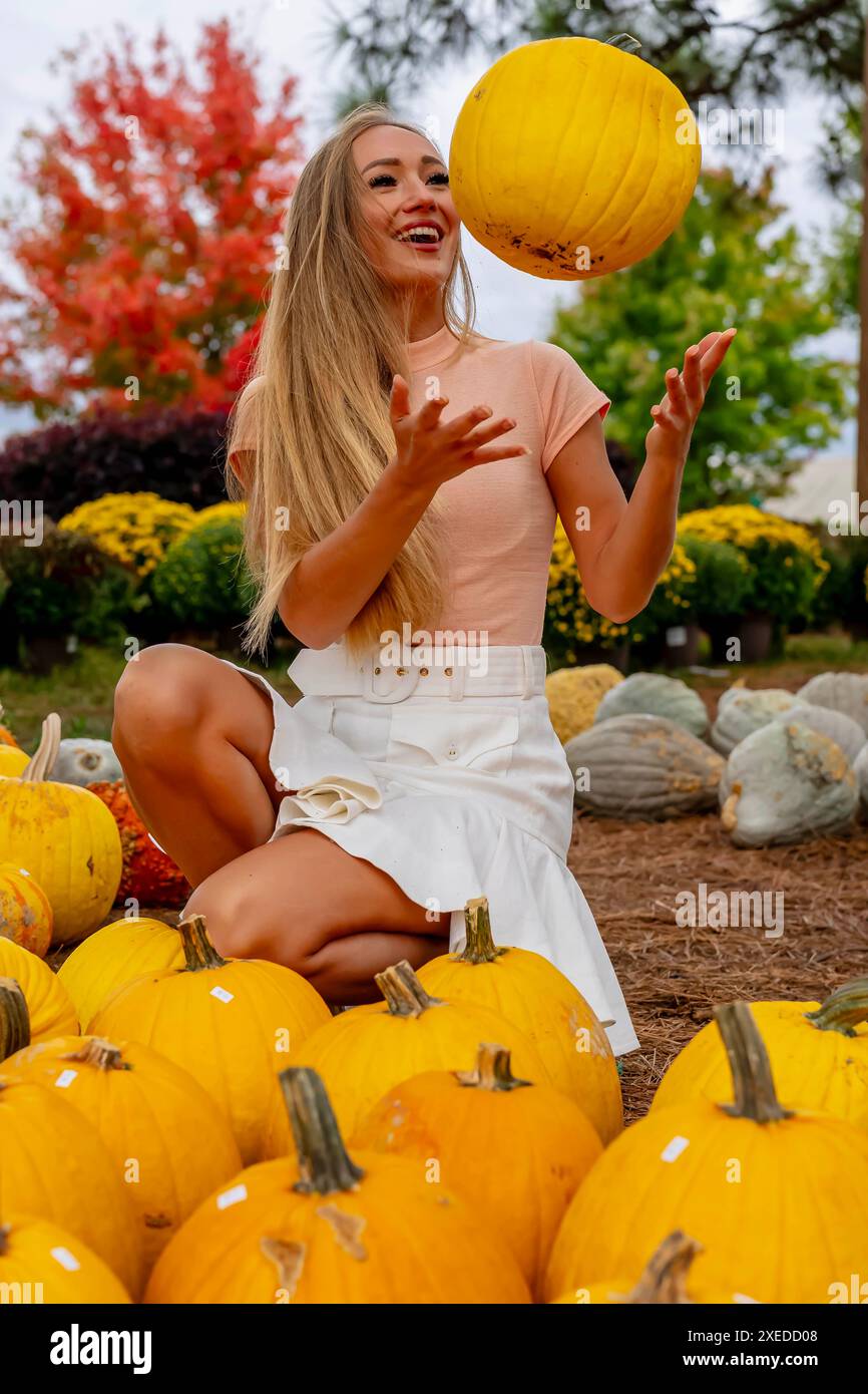 Un beau modèle européen Blonde aime magasiner pour des citrouilles et des fleurs pour les vacances d'Halloween Banque D'Images