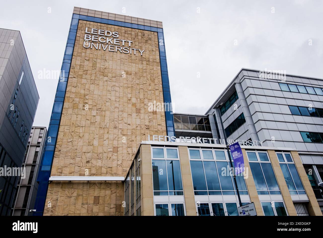 Leeds Angleterre : 3 juin 2024 : campus extérieur de l'Université Leeds Beckett. Extérieur grand angle avec arbres et signalisation Uni, bannière violette Banque D'Images