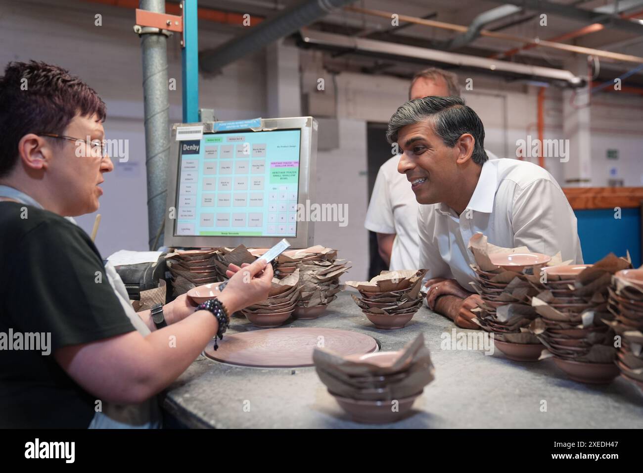 RETRANSMISSION DE LA LÉGENDE CORRECTE AU premier ministre SUNAK, Rishi Sunak, parlant à un membre du personnel lors de sa visite à l'usine de poterie Denby, Ripley, alors qu'il se trouvait sur la piste de la campagne électorale générale. Date de la photo : jeudi 27 juin 2024. Banque D'Images