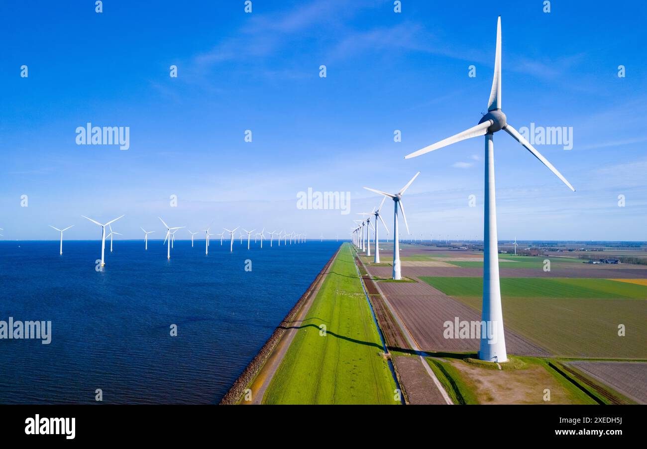 Un paysage serein où une rangée d'éoliennes se dresse à côté d'un plan d'eau tranquille dans les pays-Bas Flevoland pendant Banque D'Images