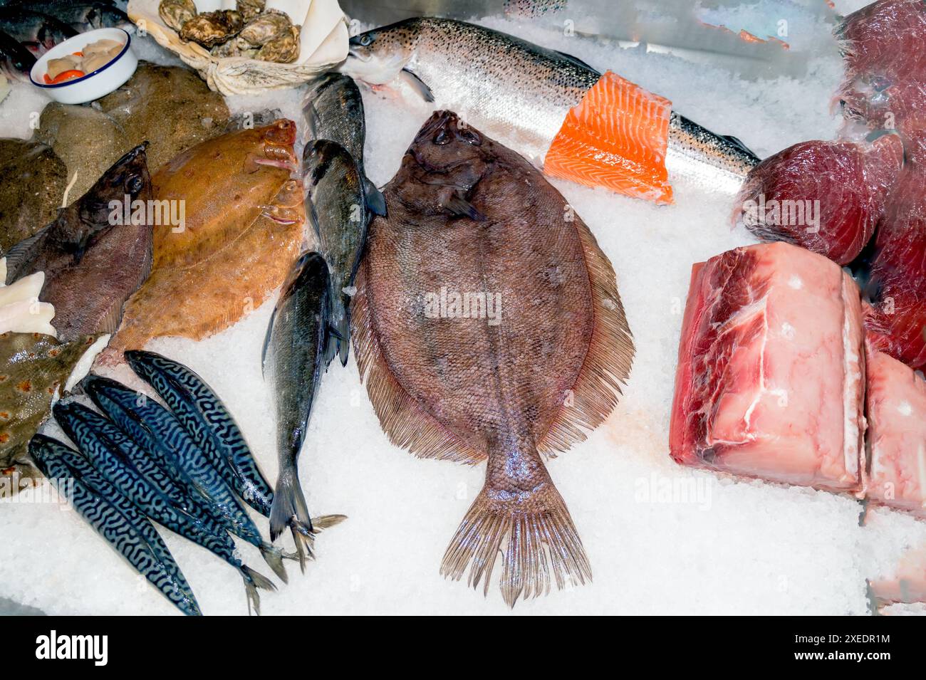Poisson frais déposé dans de la glace sur le plateau de présentation des poissonniers Banque D'Images