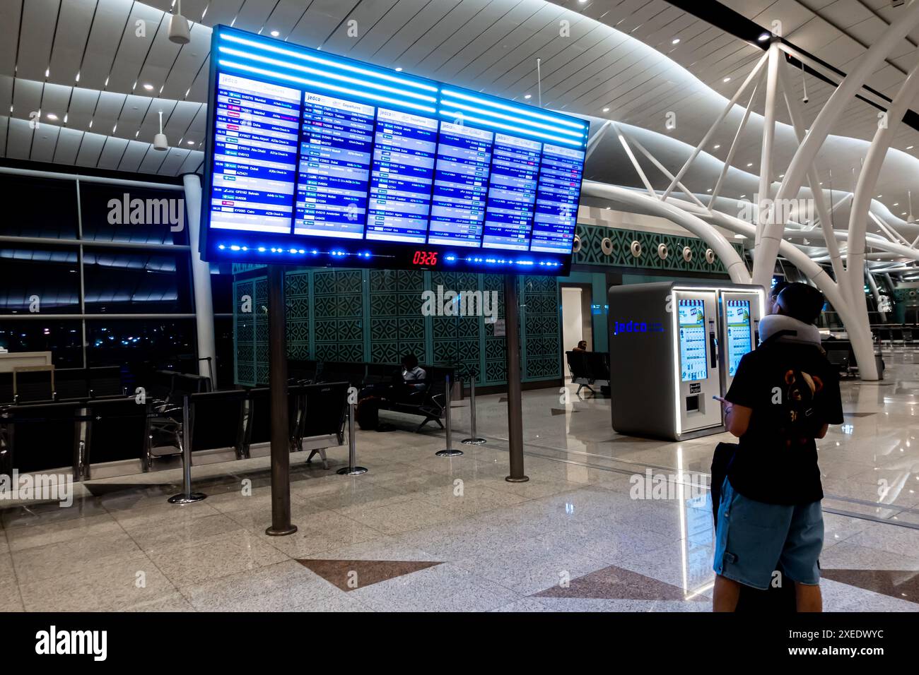 Touriste regardant l'écran d'information des vols, départs, JEDCO bilingue anglais et arabe, Aéroport Jeddah, Arabie Saoudite, JED, Asie Banque D'Images