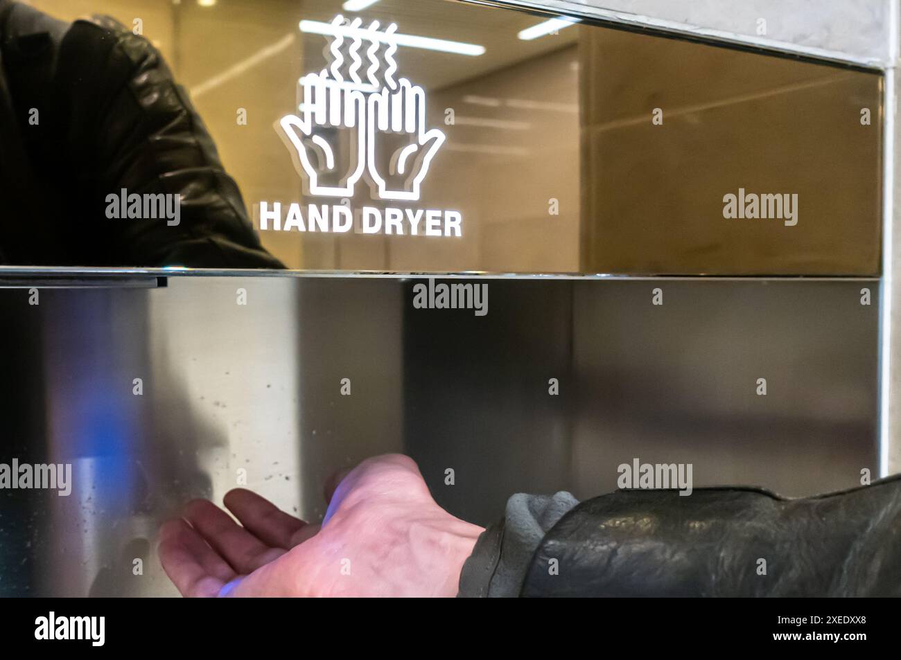 Homme main sous sèche-mains dans une salle de bain Zayed International Airport, Abu Dhabi, eau Banque D'Images