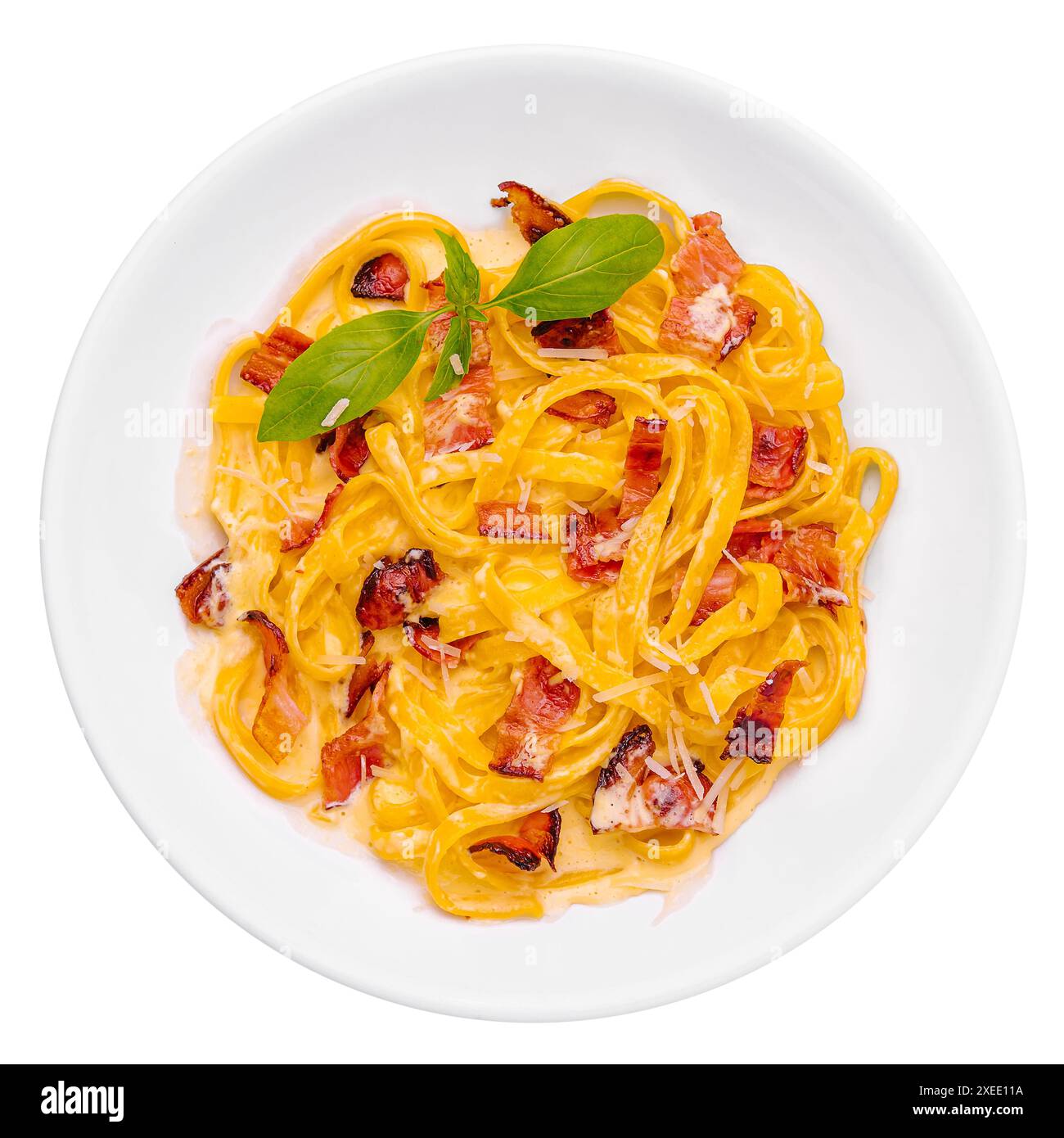 Pâtes au bacon et basilic sur assiette blanche Banque D'Images