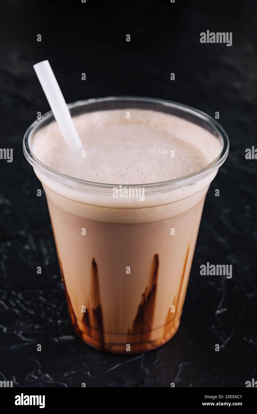 milkshake dans une tasse en plastique sur fond noir Banque D'Images