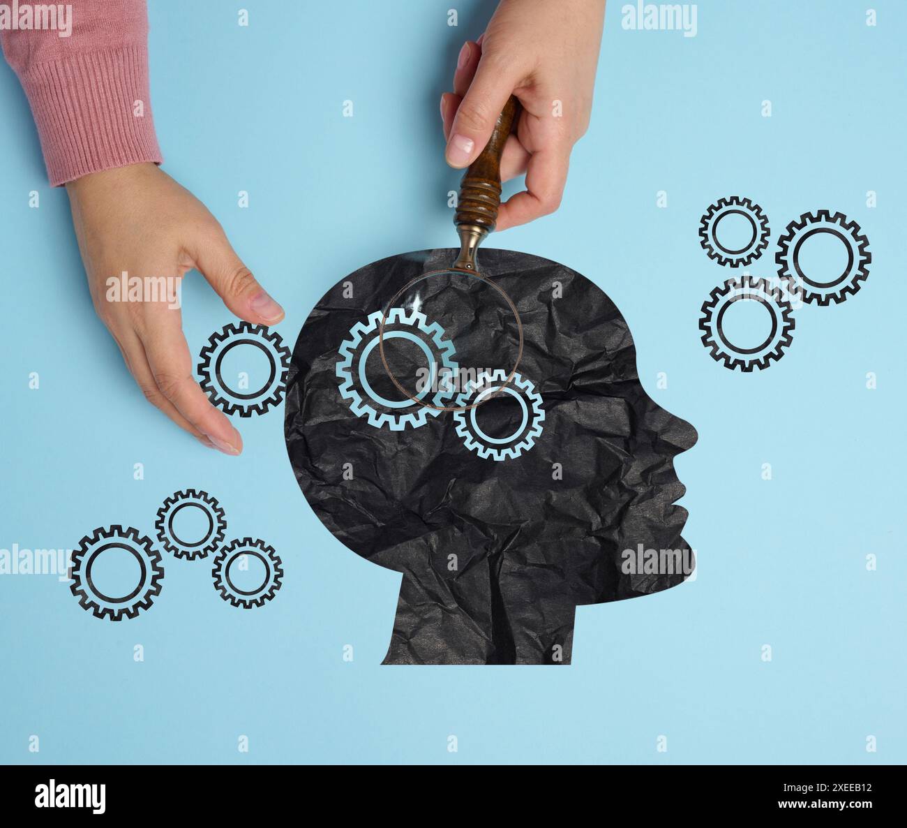 Silhouette d'une tête humaine et d'une main de femme avec une loupe. Concept de santé mentale Banque D'Images