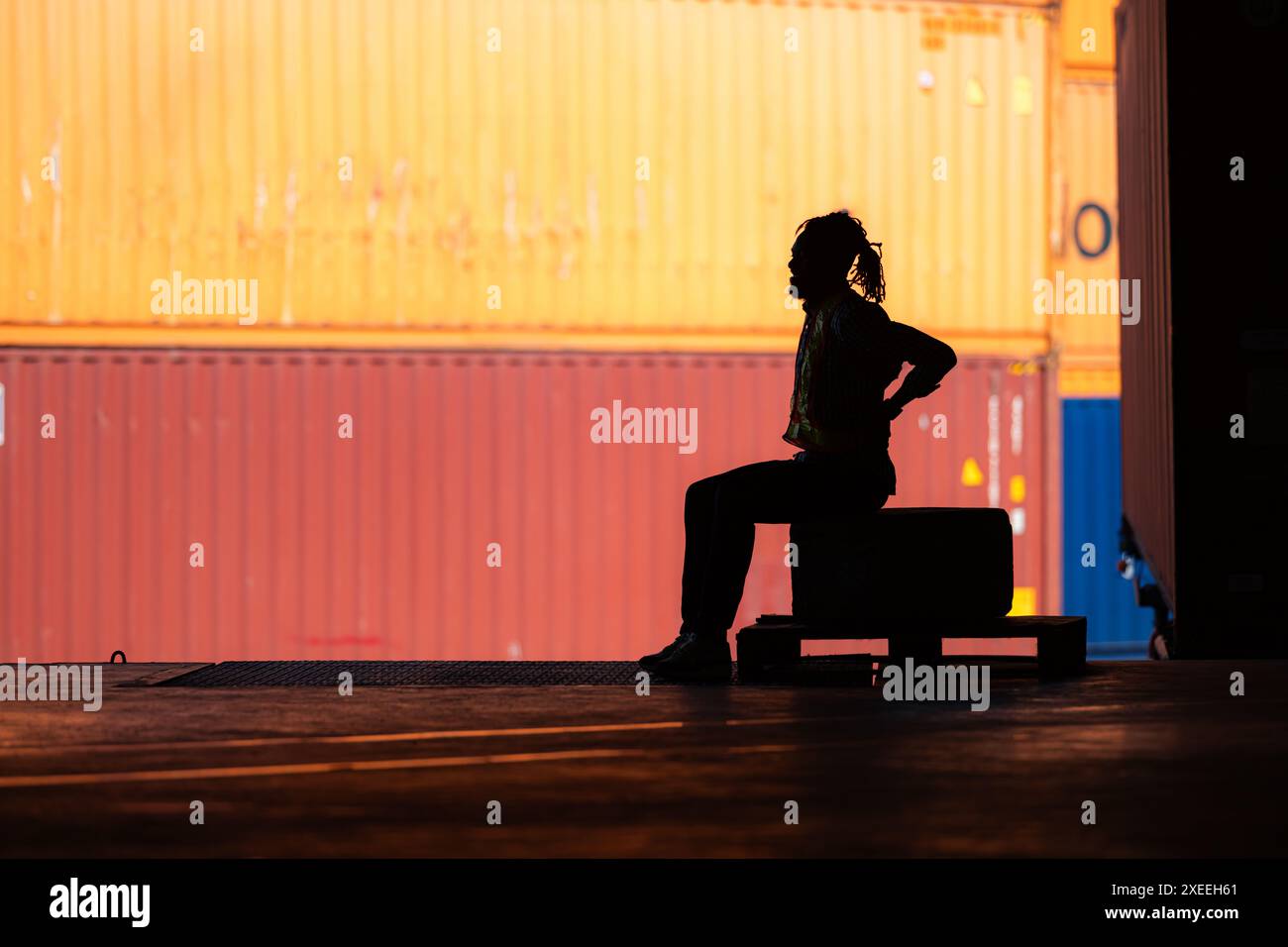 Mal de dos de travailleur d'entrepôt de travail acharné tout en étant assis et relaxant, Silhouette concept Banque D'Images