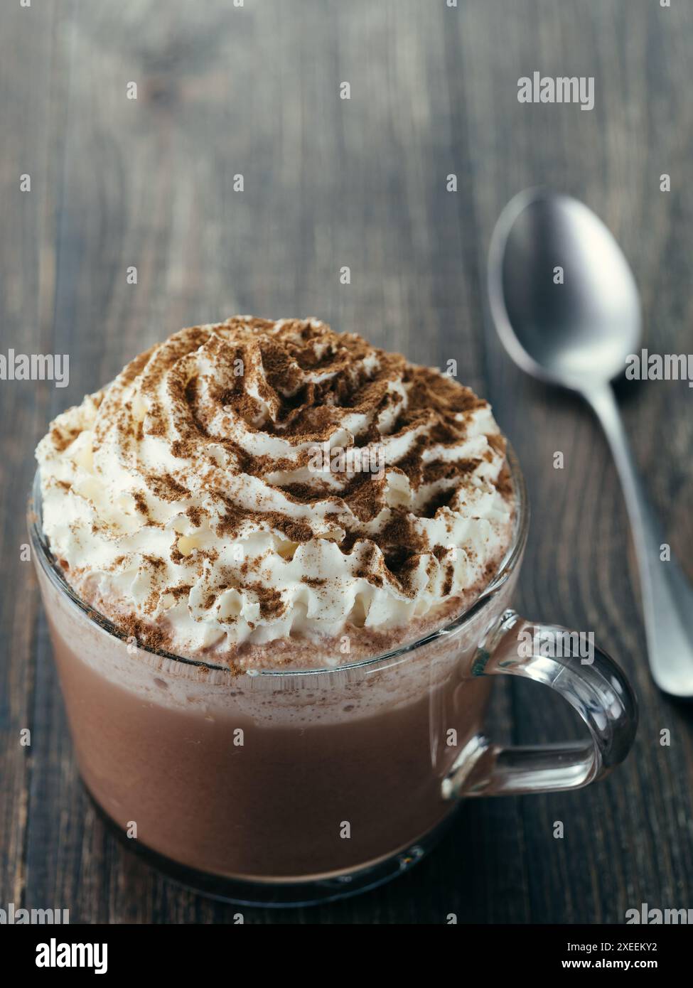 Tasse en verre avec du chocolat chaud et crème fouettée Banque D'Images
