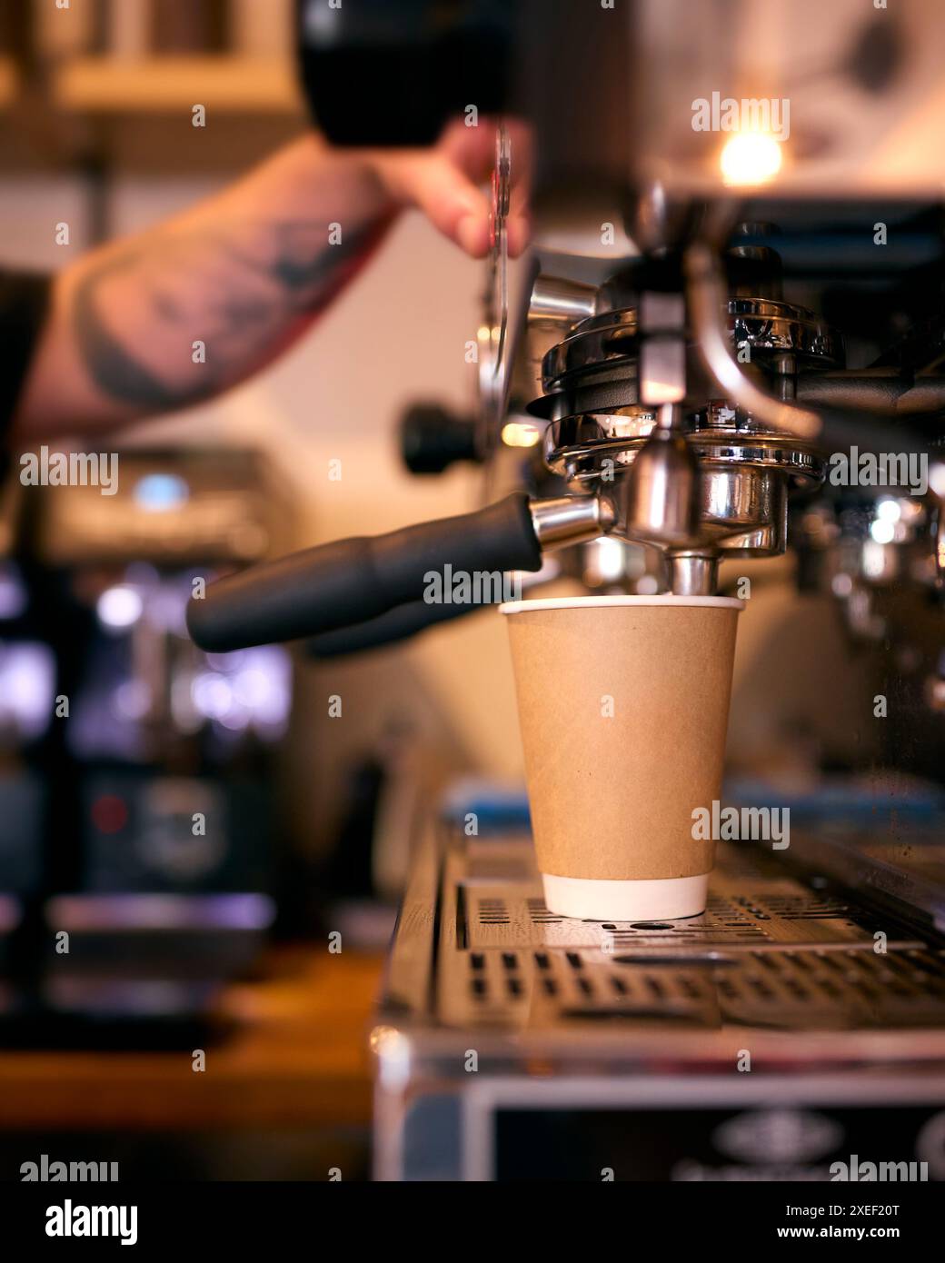 Gros plan sur Barista at machine préparant du café à emporter dans un café ou un café-restaurant Banque D'Images