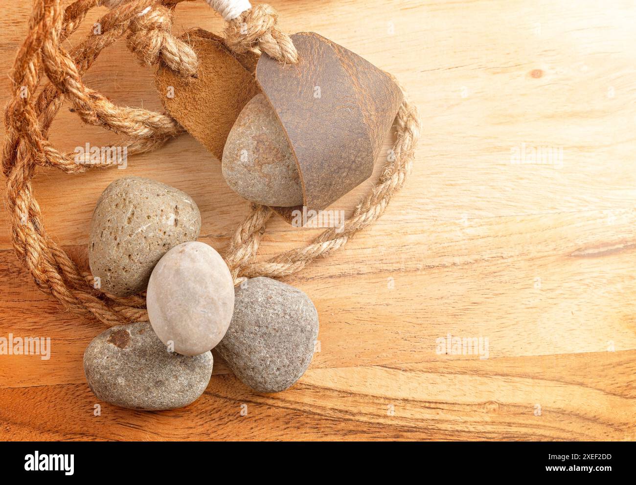 Sling Shot and Stones on a Wooden table de l'histoire de David et Goliath dans la Bible Banque D'Images
