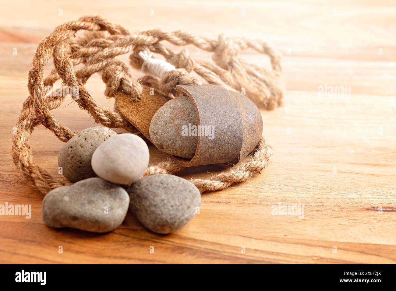 Sling Shot and Stones on a Wooden table de l'histoire de David et Goliath dans la Bible Banque D'Images