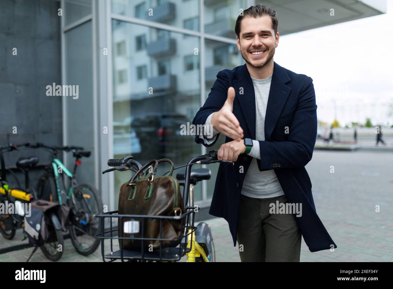 L'homme freelance souriant européen dit tend sa main tout en grimpant sur le vélo Banque D'Images