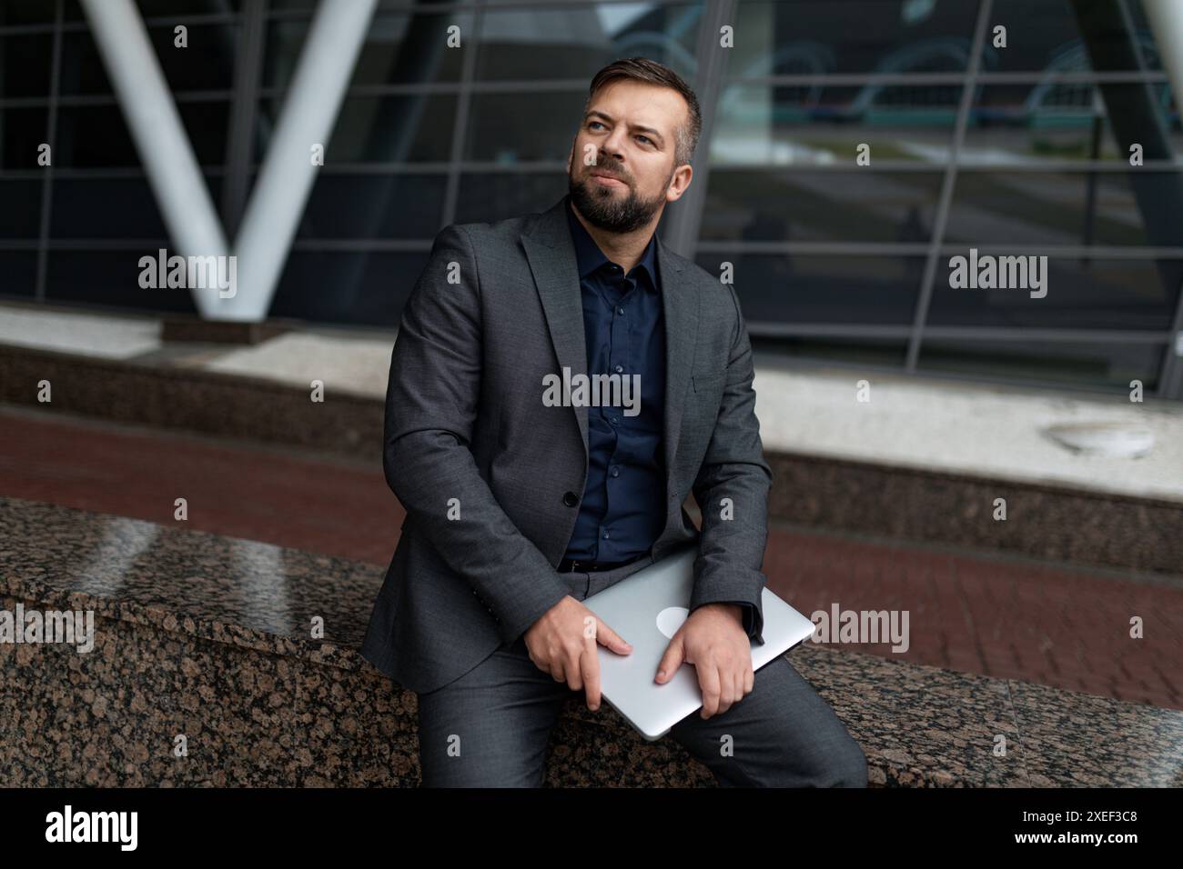 Architecte masculin pensif avec des documents sur le fond de l'objet construit Banque D'Images