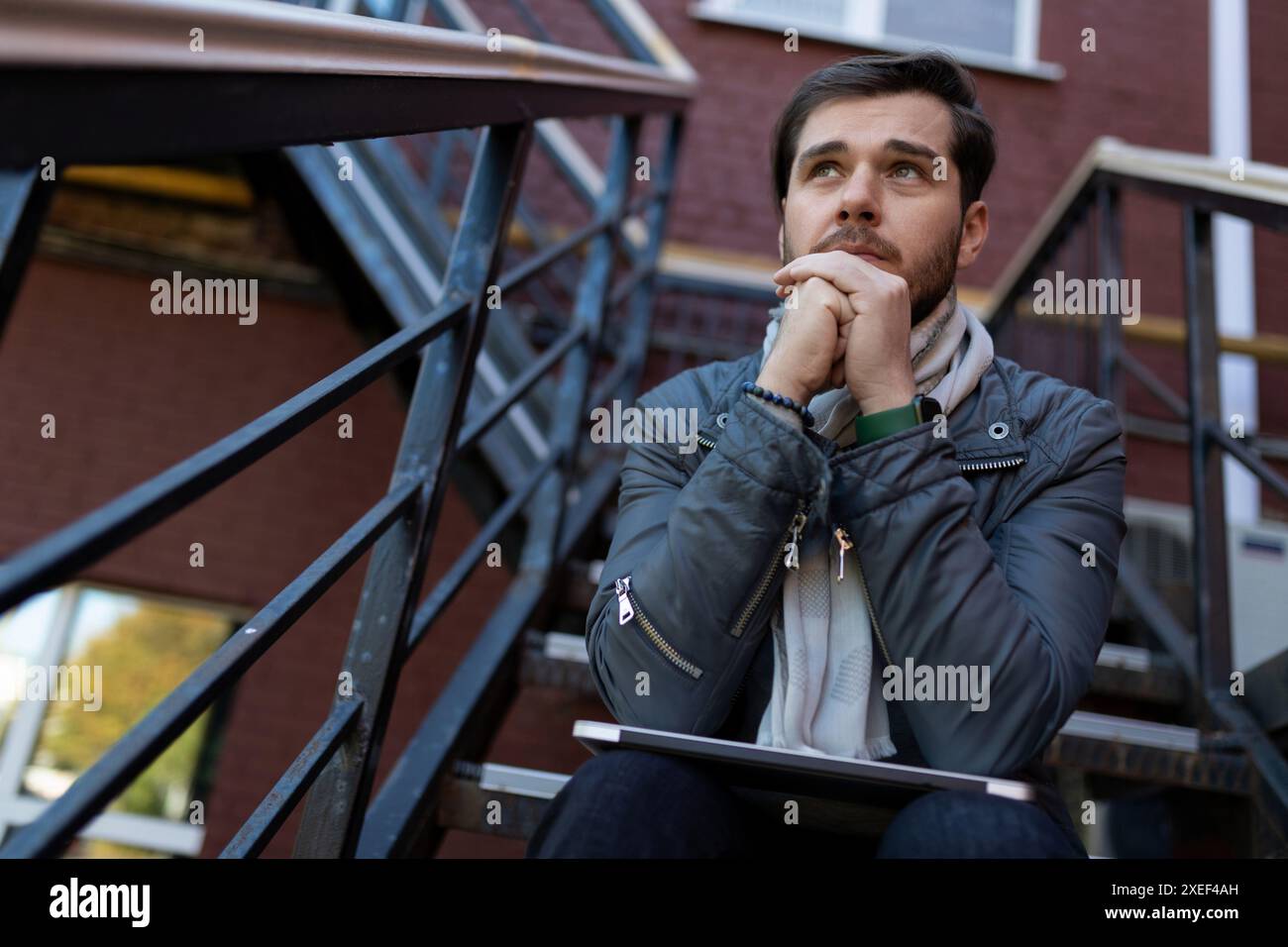 L'homme caucasien prospère s'assoit soigneusement sur les escaliers dans la rue Banque D'Images