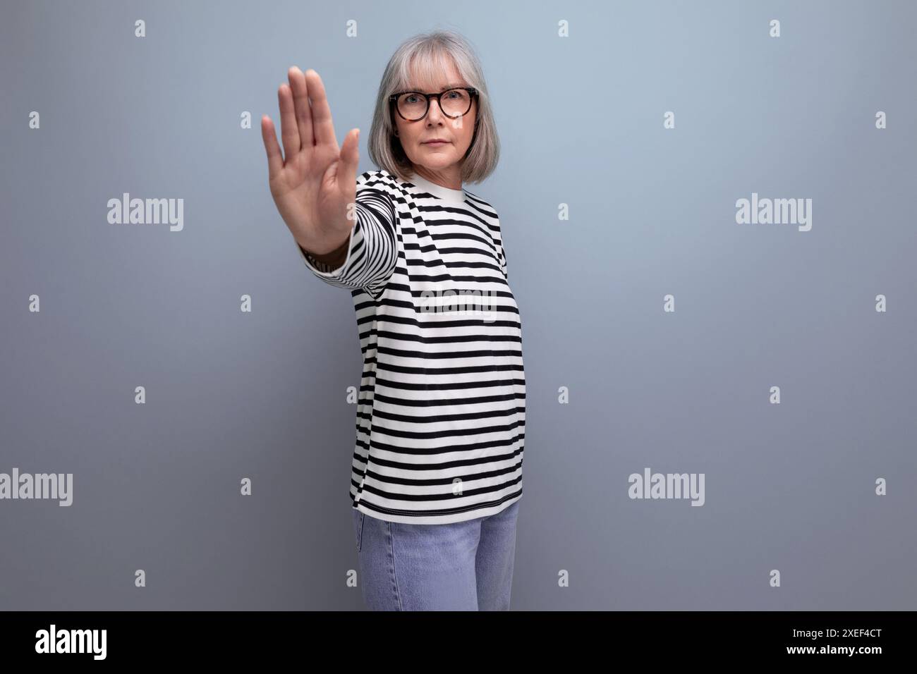 Portrait d'une vieille femme avec les cheveux gris dans une image à la mode sur un fond de studio lumineux Banque D'Images