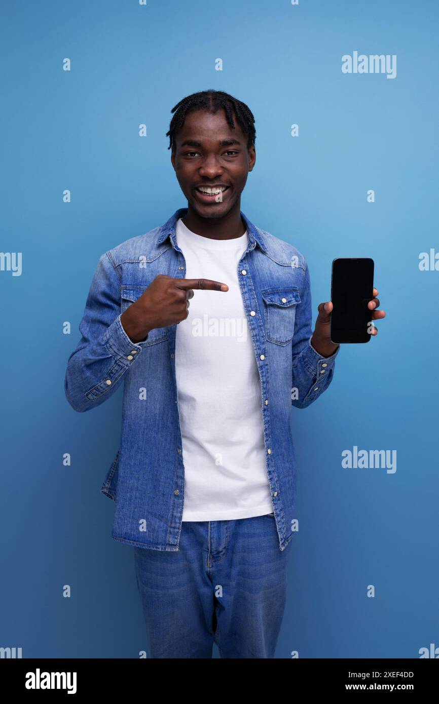 Homme américain élégant avec dreadlocks noirs utilise smartphone Banque D'Images